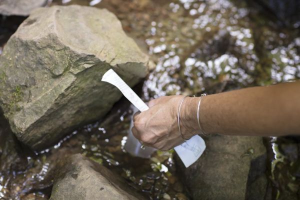 Persona tomando una muestra de agua con una tira reactiva para comprobar su calidad